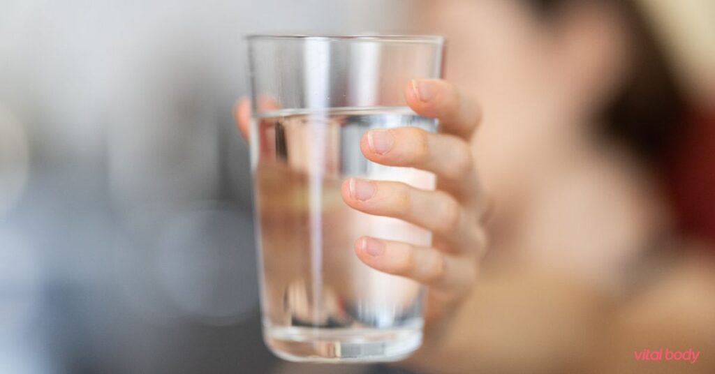 A hand holding a glass of water, a simple daily habit that supports healthy weight loss