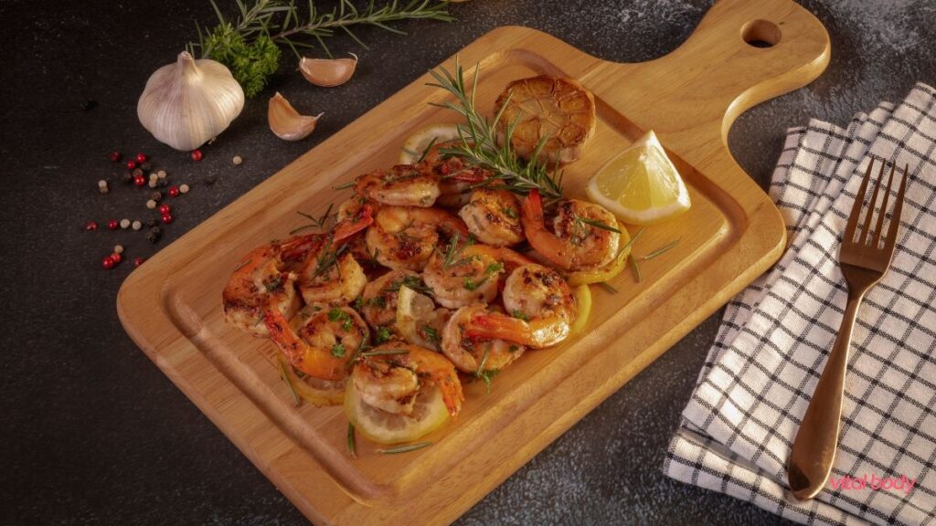 Grilled shrimp with rosemary, lemon and roasted garlic on a wooden board